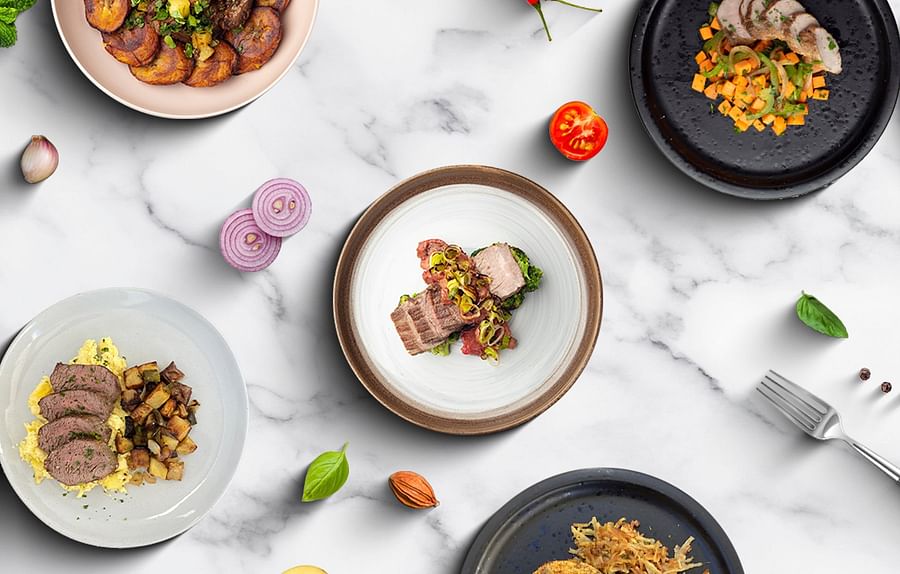 Plate filled with paleo-friendly foods including lean meats, vegetables, fruits, and nuts